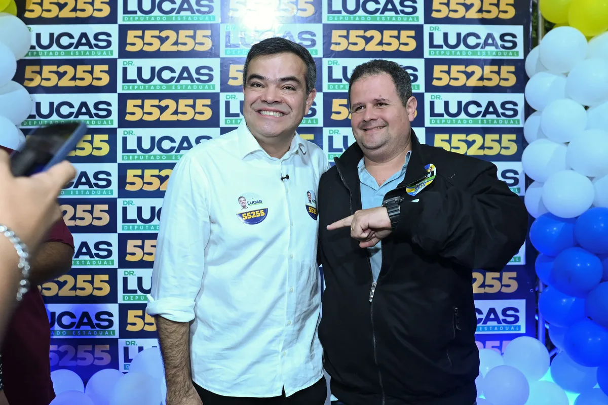 Dr. Lucas 55255 ao lado de um apoiador, os dois apontando um para o outro