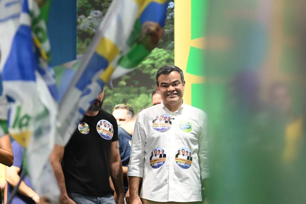 Dr. Lucas 55255 sorrindo no meio das bandeiras da campanha