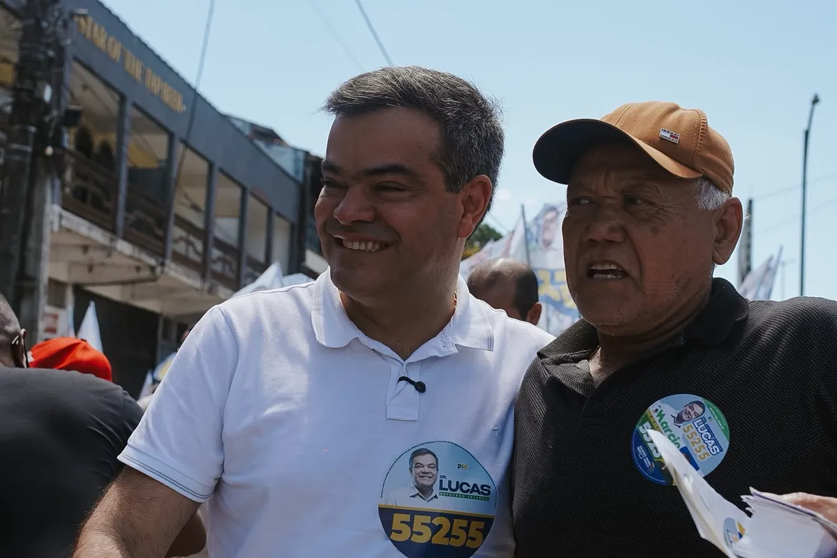 Dr. Lucas 55255 sorri ao lado de um morador na caminhada em Rio das Ostras