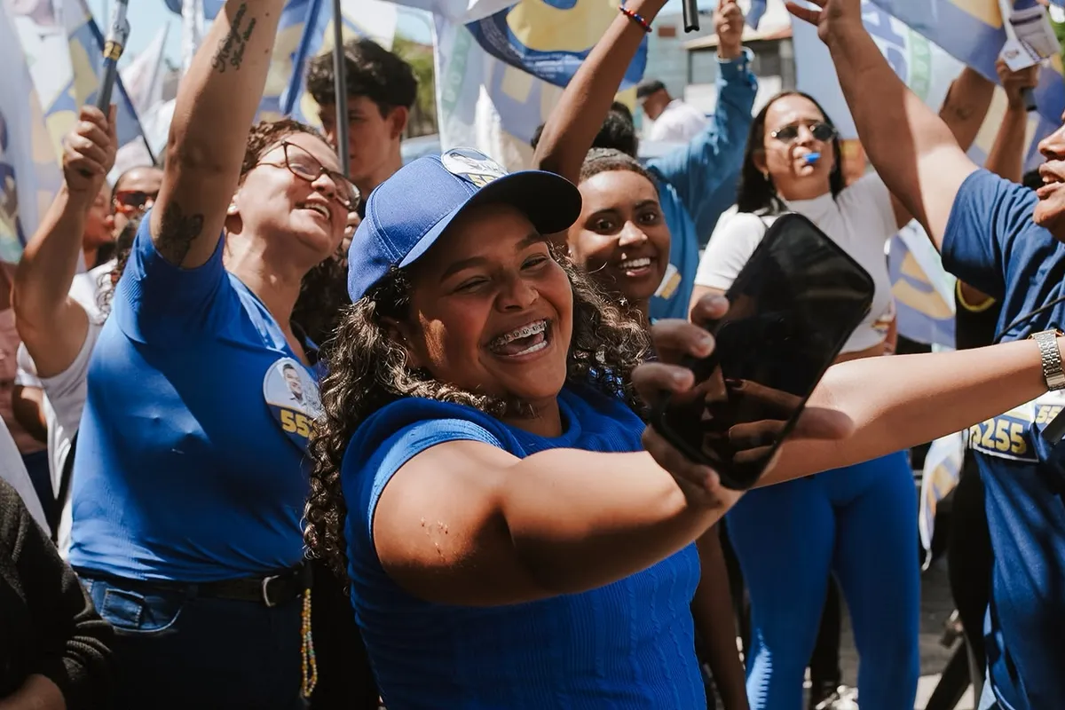 Apoiadoras do Dr. Lucas 55255 comemoram com bandeiras erguidas na caminhada em Rio das Ostras