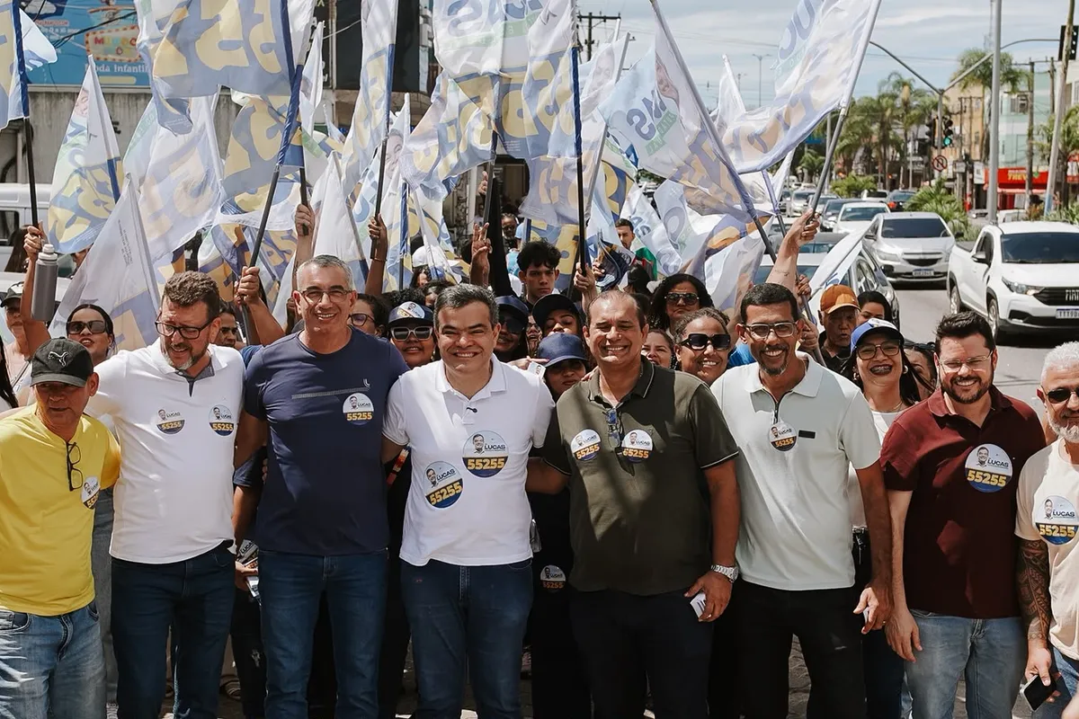 Dr. Lucas 55255 à frente de dezenas de apoiadores com bandeiras, na caminhada pelo centro de Rio das Ostras