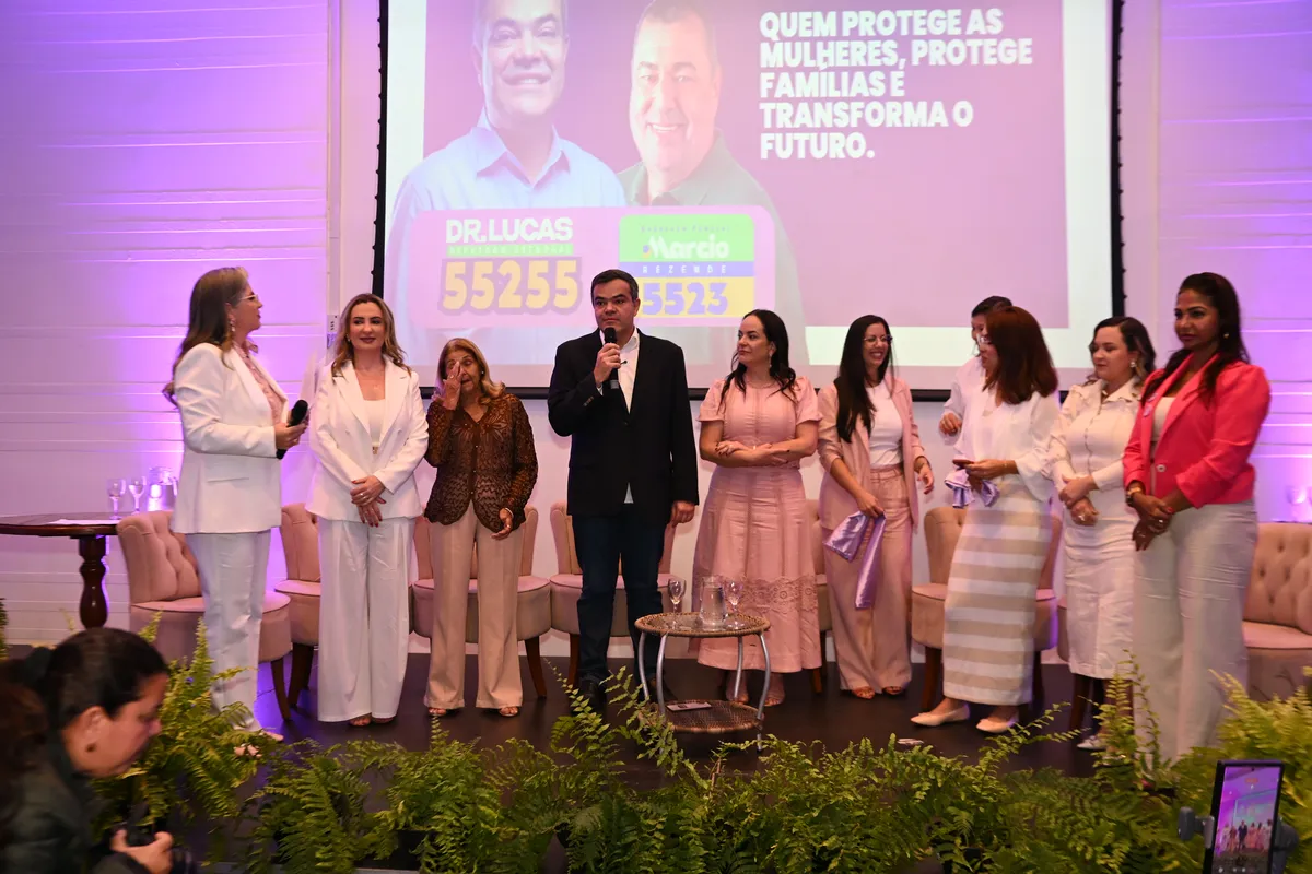 Dr. Lucas 55255 fala ao microfone no palco, ao lado das participantes do Encontro Mulheres do Coração