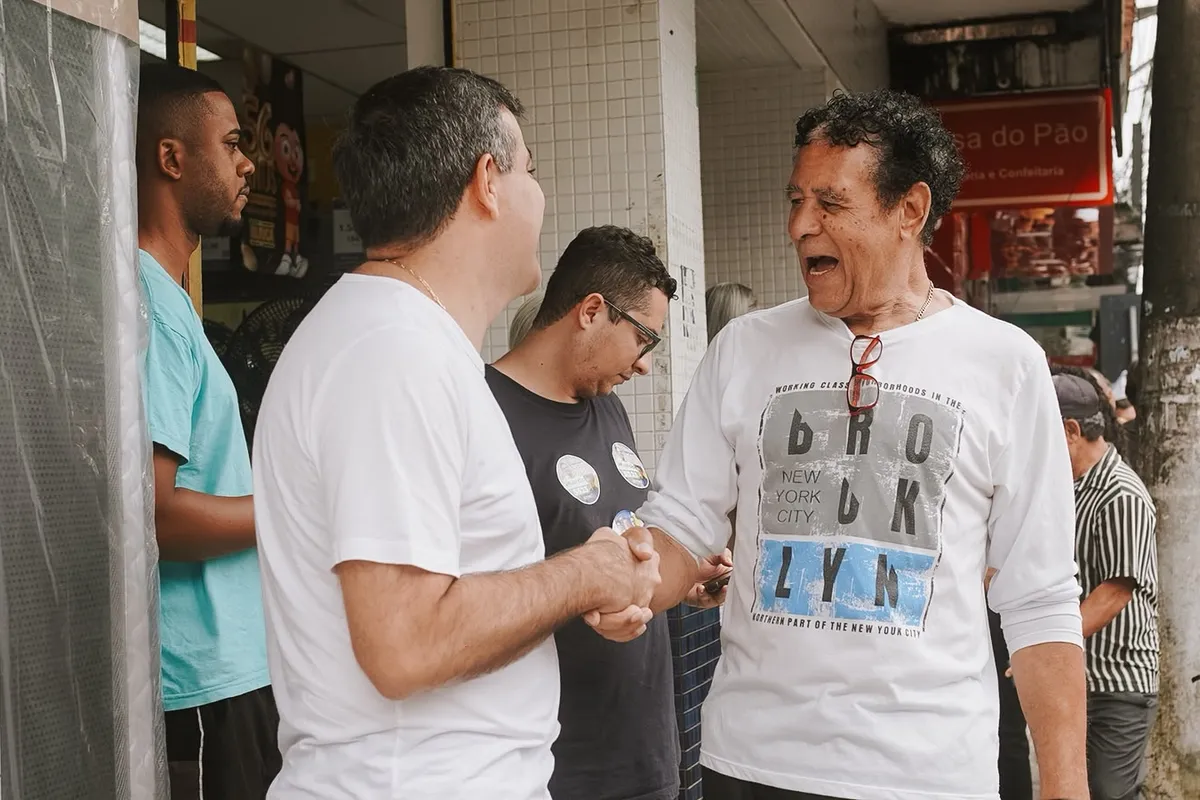 Dr. Lucas 55255 aperta a mão de um morador na calçada, na caminhada em Conceição de Macabu