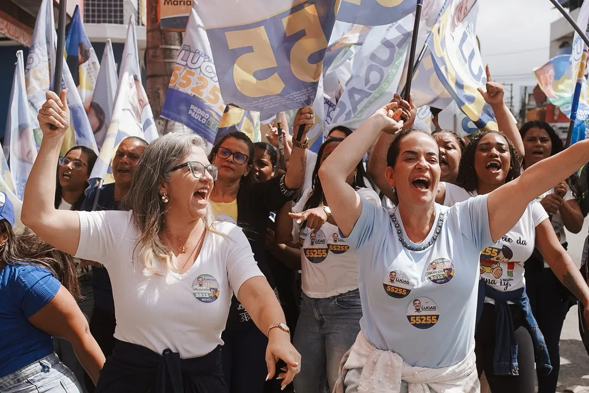 Apoiadoras do Dr. Lucas 55255 de braços para o alto, no meio das bandeiras, em Rio das Ostras