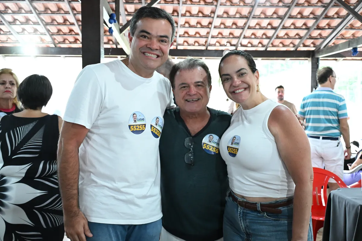 Dr. Lucas 55255 sorri abraçado a dois apoiadores no Encontro na AMA