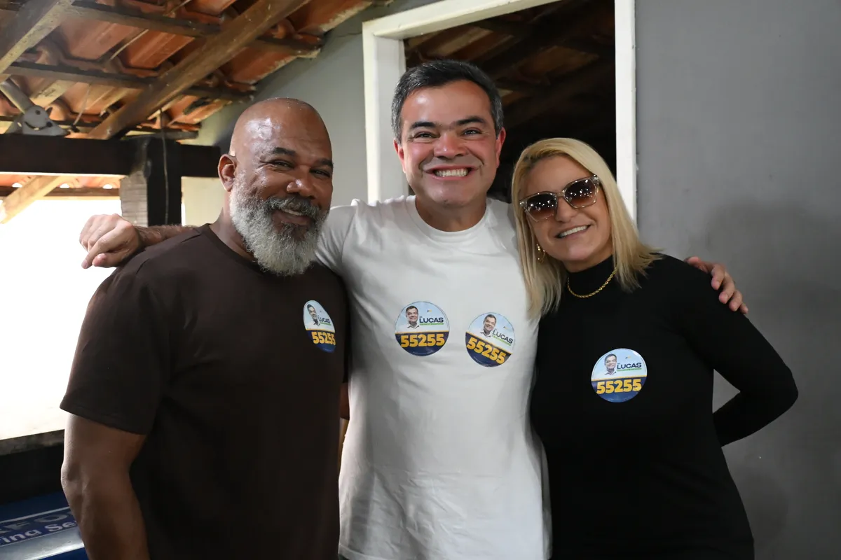 Dr. Lucas 55255 abraçado a dois apoiadores com adesivos 55255 no Encontro na AMA
