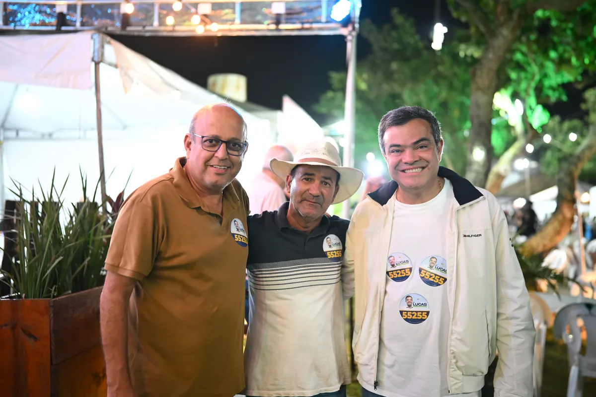 Dr. Lucas 55255 ao lado de dois apoiadores, um deles de chapéu, na Quissamã Expo