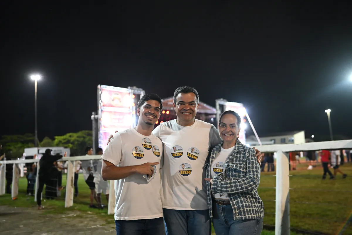 Dr. Lucas 55255 com dois apoiadores diante do palco da Quissamã Expo